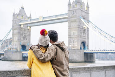 London, United Kingdom, Couple looking at Tower bringe with arms around - DGOF00508