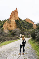 Hiker photographing Mina de Oro Romana, Las Medulas, Castile and Leon, Spain - DGOF00520