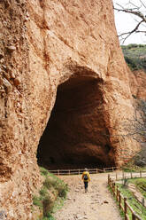 Wanderer am Eingang eines Stollens, Mina de Oro Romana, ehemalige Goldmine, Las Medulas, Kastilien und Leon, Spanien - DGOF00524