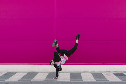 Young man listening to music and dancing breakdance - ERRF02790