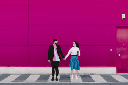 Couple standing on crosswalk, face to face and holding hands - ERRF02806