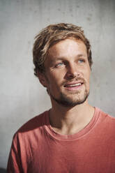 Portrait of man wearing red t-shirt looking up - PNEF02388