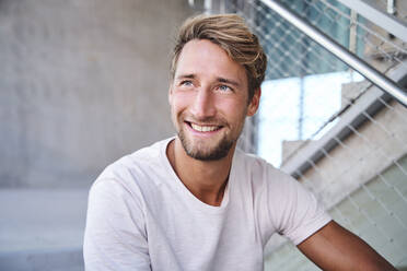 Porträt eines lächelnden jungen Mannes mit weißem T-Shirt - PNEF02402