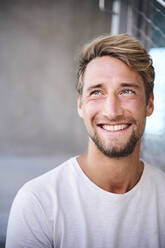 Portrait of smiling young man wearing white t-shirt - PNEF02404