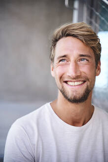 Porträt eines lächelnden jungen Mannes mit weißem T-Shirt - PNEF02404