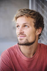 Portrait of young man wearing t-shirt looking up - PNEF02406