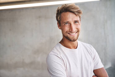 Porträt eines lächelnden jungen Mannes mit weißem T-Shirt - PNEF02413