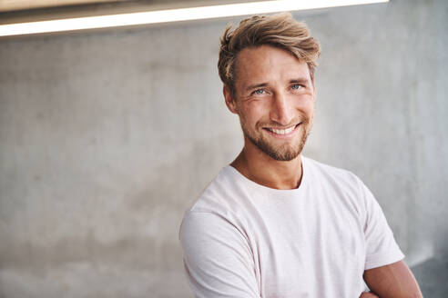 Portrait of smiling young man wearing white t-shirt - PNEF02413