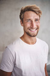 Portrait of happy young man wearing white t-shirt - PNEF02414