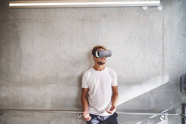 Young man wearing virtual reality goggles - PNEF02416