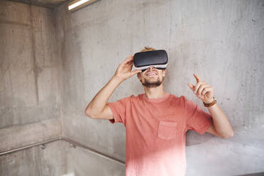 Young man wearing virtual reality goggles - PNEF02421