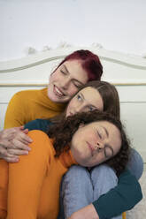 Porträt von drei Schwestern, die miteinander kuscheln - PSTF00653