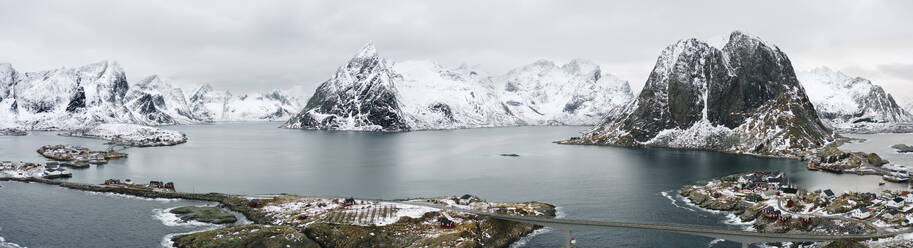 Norwegen, Reine, Luftpanorama des Fischerdorfs am Ufer der Insel Moskenesoya mit Bergen im Hintergrund - MPPF00517