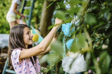 Mädchen dekoriert den Garten für eine Geburtstagsfeier - SODF00620