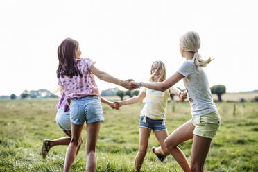 Happy girls dancing on a field together - SODF00634