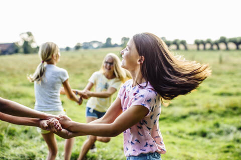 Happy girls dancing on a field together stock photo