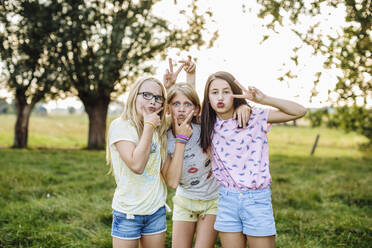 Portrait of playful girls pulling funny faces outdoors - SODF00648