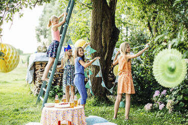 Mädchen dekorieren den Garten für eine Geburtstagsfeier - SODF00653