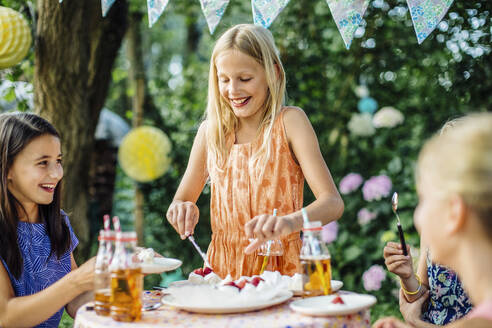 Mädchen serviert Kuchen auf einer Geburtstagsfeier im Freien - SODF00669
