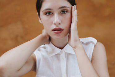 Portrait of female teenager in front of a brown wall - TCEF00226