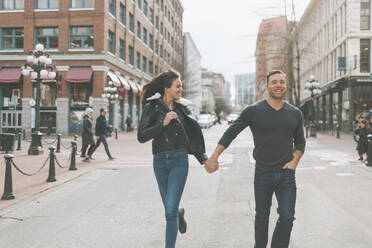 Happy couple walking down a city street, Vancouver, Canada - CMSF00096