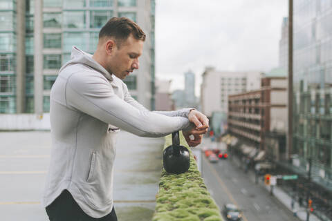 Mann beim Training mit einer Kettlebell in der Stadt, Kanada, lizenzfreies Stockfoto