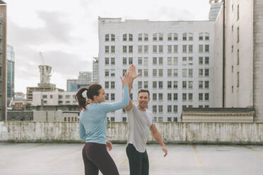 Man and woman high five during a workout in the city, Vancouver, Canada - CMSF00100