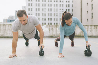 Man and woman doing push ups in the city, Vancouver, Canada - CMSF00104