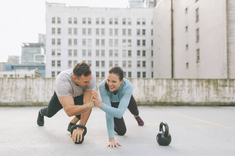 Mann und Frau geben sich beim Sport in der Stadt die Hand, Vancouver, Kanada, lizenzfreies Stockfoto