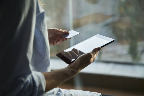 Close-up of woman using tablet and credit card - PNEF02431