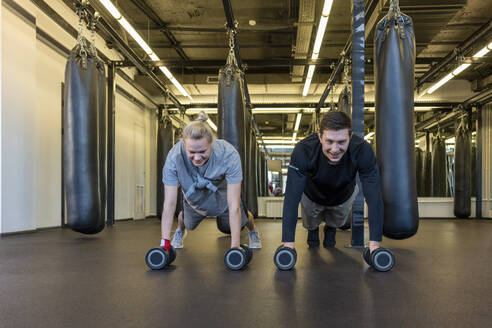 Junger Mann und Frau trainieren in einem Fitnessstudio - VPIF02067