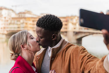 Zärtliches junges Paar, das sich küsst und ein Selfie in der Stadt Florenz, Italien, macht - FMOF00864