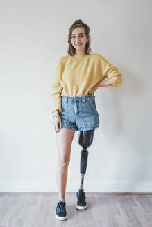 Porträt einer lächelnden jungen Frau mit Beinprothese - FBAF01293