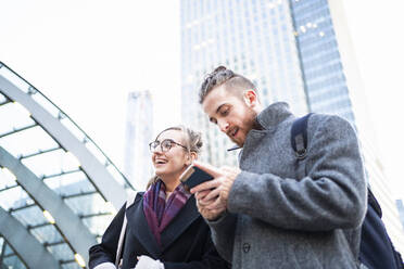 Junges Paar mit Mobiltelefon in der Stadt, London, UK - FBAF01300