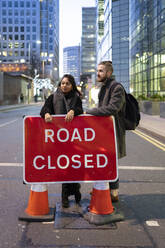 Junges Paar steht auf einer gesperrten Straße in der Stadt, London, UK - FBAF01311