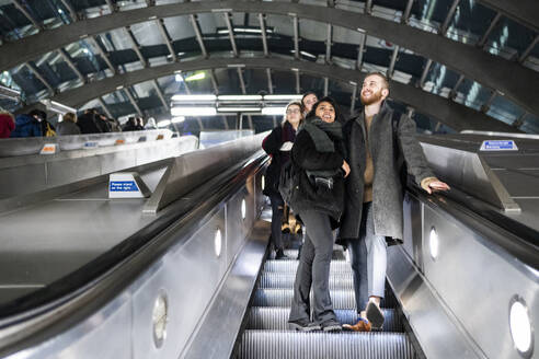 Young couple on escalator at subway station - FBAF01322