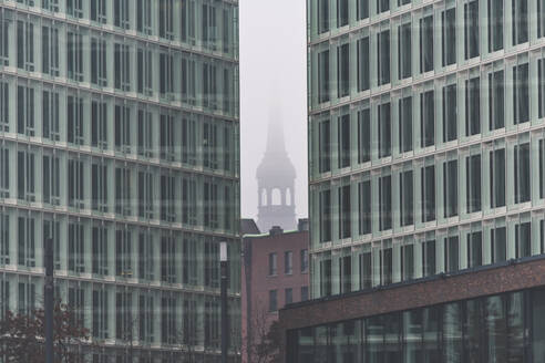 Deutschland, Hamburg, Nebel umhüllt Turm der St. Katharinenkirche zwischen Ericusspitze Gebäuden - KEBF01482