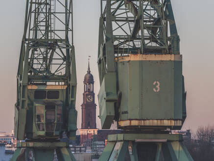 Deutschland, Hamburg, Turm der St. Michaelskirche zwischen zwei Industriekränen - KEBF01501