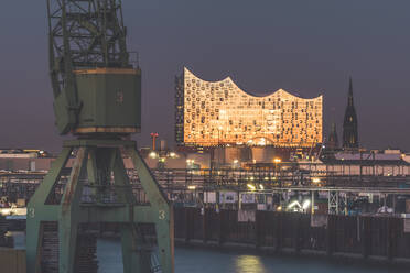 Deutschland, Hamburg, Hafenkran und Elbphilharmonie in der Abenddämmerung - KEBF01503