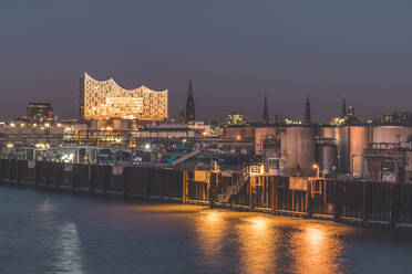 Germany, Hamburg, Kleiner Grasbrook harbor at dusk with Elbphilharmonie hall in background - KEBF01504