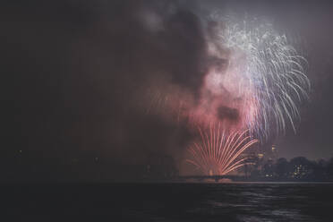 Germany, Hamburg, Fireworks exploding over Outer Alster Lake at night - KEBF01509