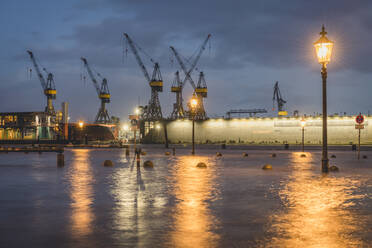 Deutschland, Hamburg, Altonaer Fischmarkt bei Hochwasser mit Hafenkränen im Hintergrund - KEBF01526