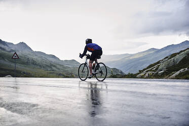 Männlicher Radfahrer auf Bergstraße, Fluela-Pass, Davos, Graubünden, Schweiz - CUF54792