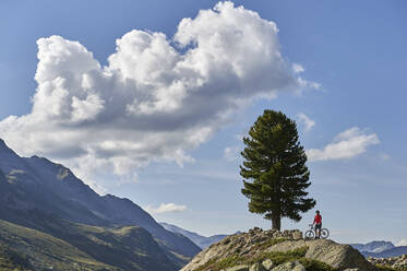 Radfahrer rastet auf einem Hügel, Fluela Pass, Davos, Graubünden, Schweiz - CUF54794