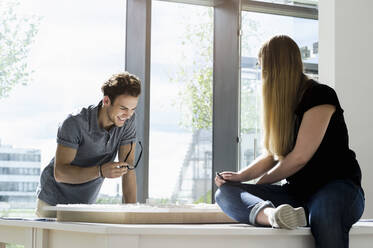 Two young architects standing at a table, working on an architectural model. - CUF54862