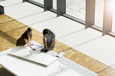 Blick von oben auf zwei junge Architekten bei der Arbeit an einem Architekturmodell. - CUF54869