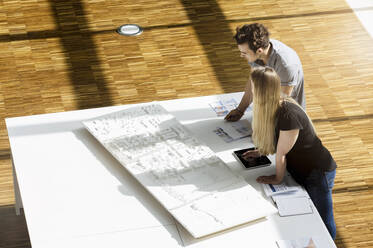 High angle view of two young architects working on an architectural model. - CUF54871