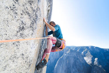 Tiefblick auf einen Bergsteiger, der die steile Wand von The Nose, El Capitan, Yosemite National Park, hinaufklettert. - CUF54884