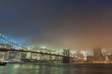 Skyline von Manhattan und Brooklyn-Brücke im Nebel in der Abenddämmerung, New York City, USA - ISF23860