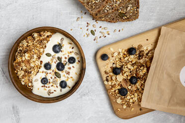 Bowl of muesli and blueberries on yogurt, multi-seed bread - ISF23870